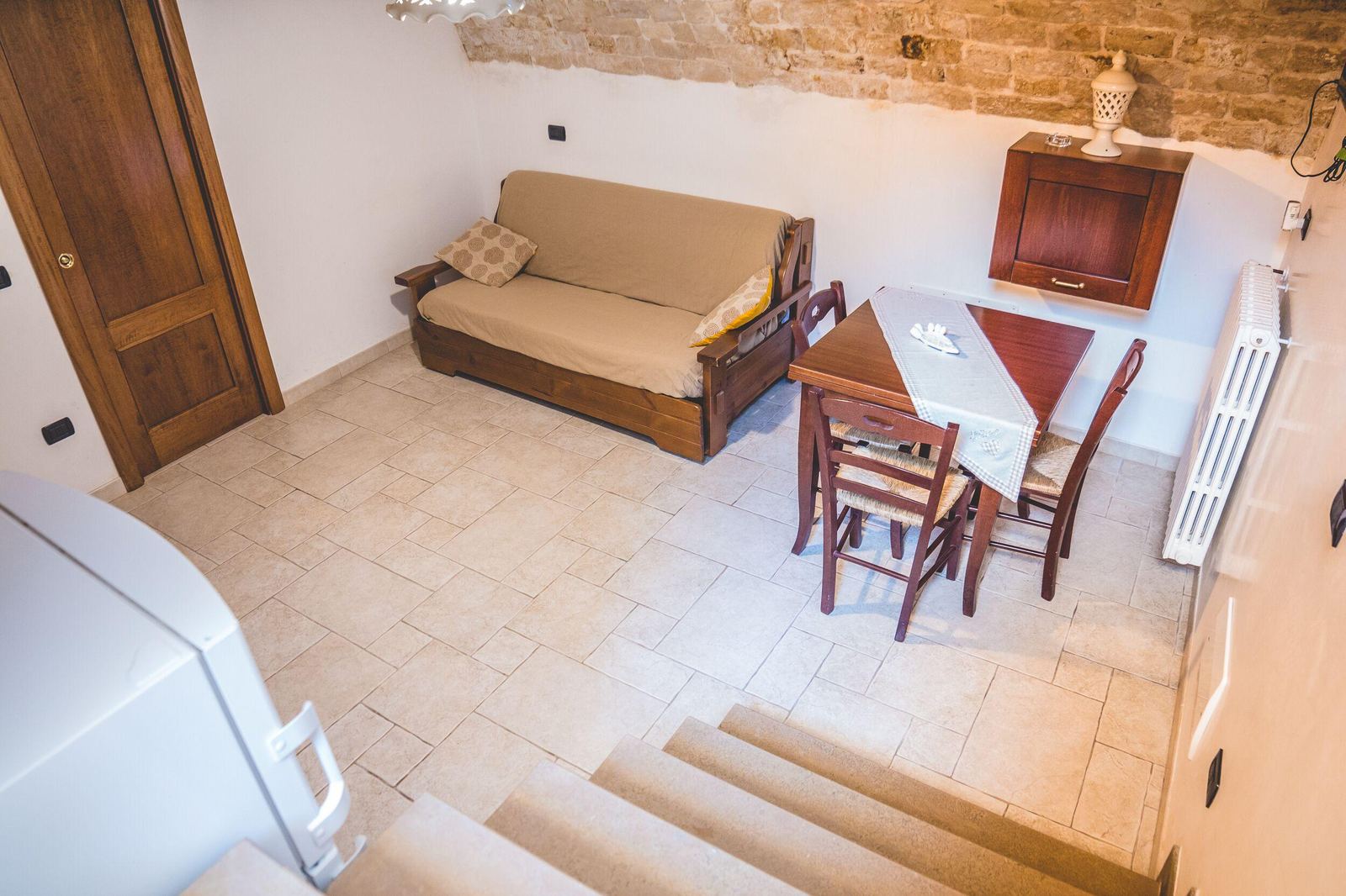 Monolocale seminterrato con divano letto e muri in pietra
