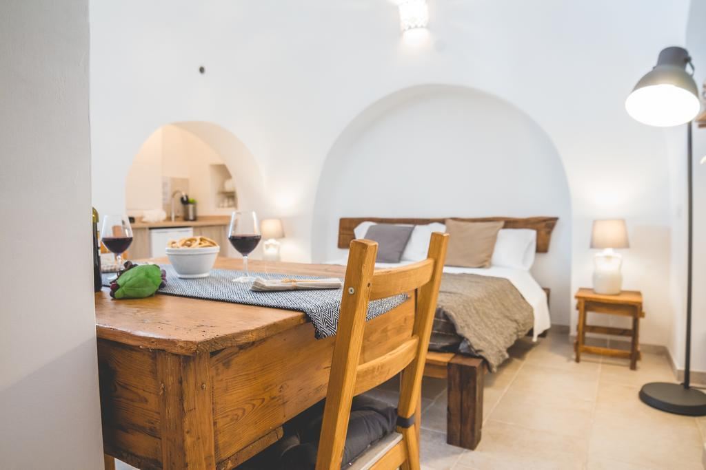 Trullo appartamento con arco in pietra e tavolo in legno